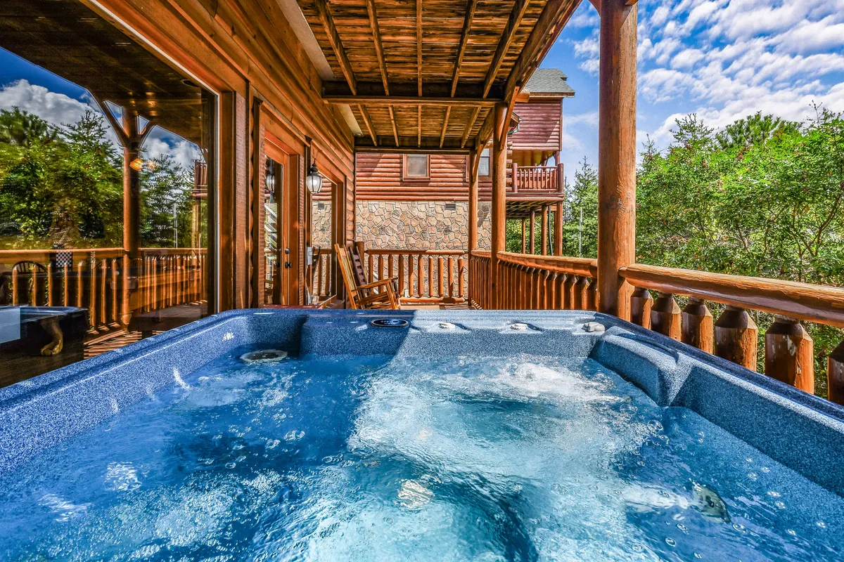 The image captures a hot tub on a wooden deck with sweeping views of the surrounding nature. The tranquil atmosphere and open vistas create a perfect setting for groups to unwind after a day of adventure.